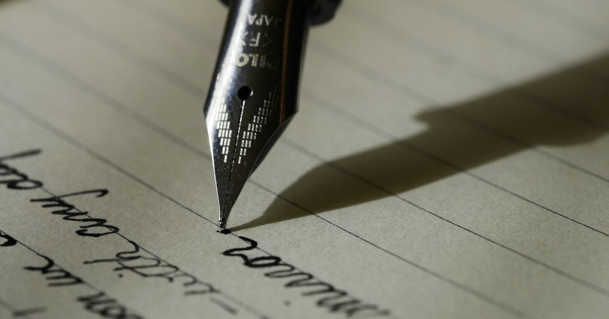Close-up of hands editing a research paper draft with a pen